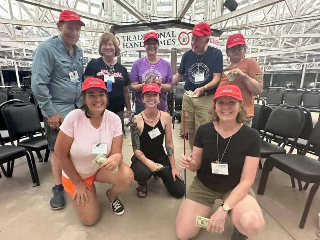 Group photo of seven people wearing red baseball hats inside the CPN Roundhouse.