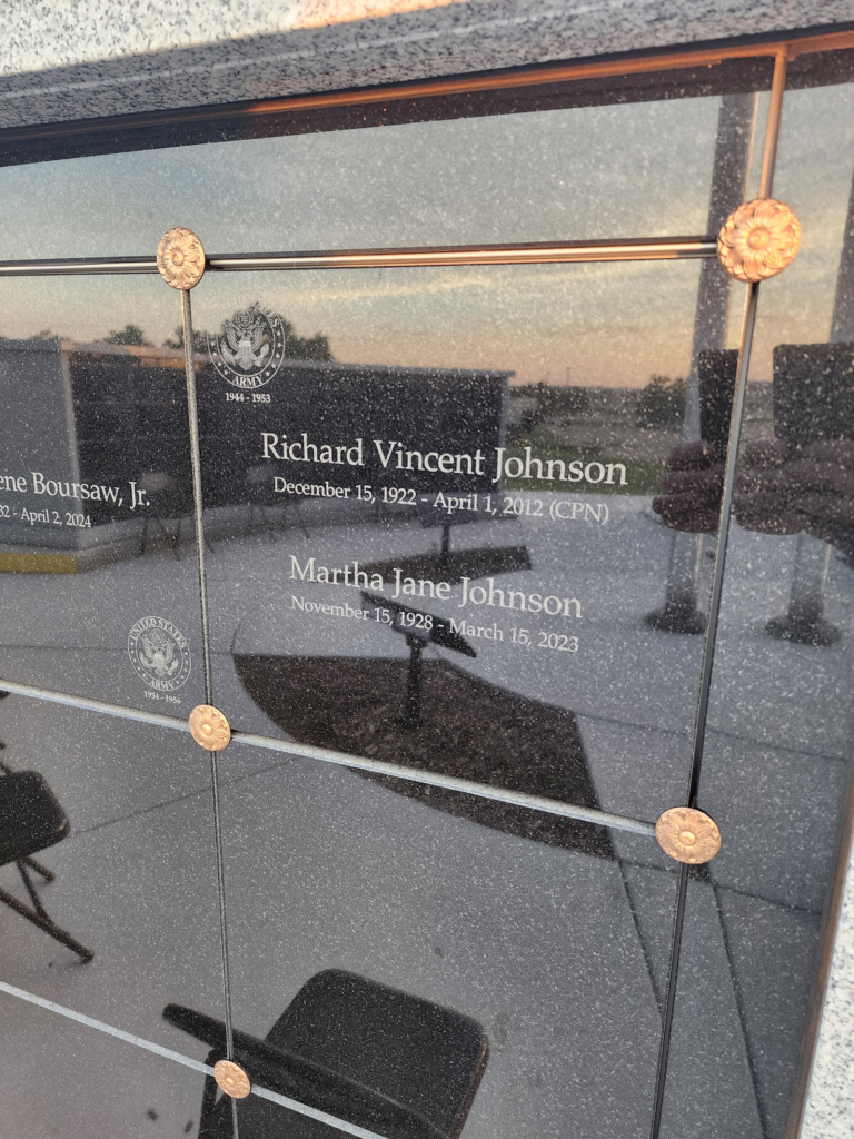 Black marble square plaque engraved with the names of Richard Vincent Johnson and Martha Jane Johnson reflects the opposite walls of the CPN columbarium.