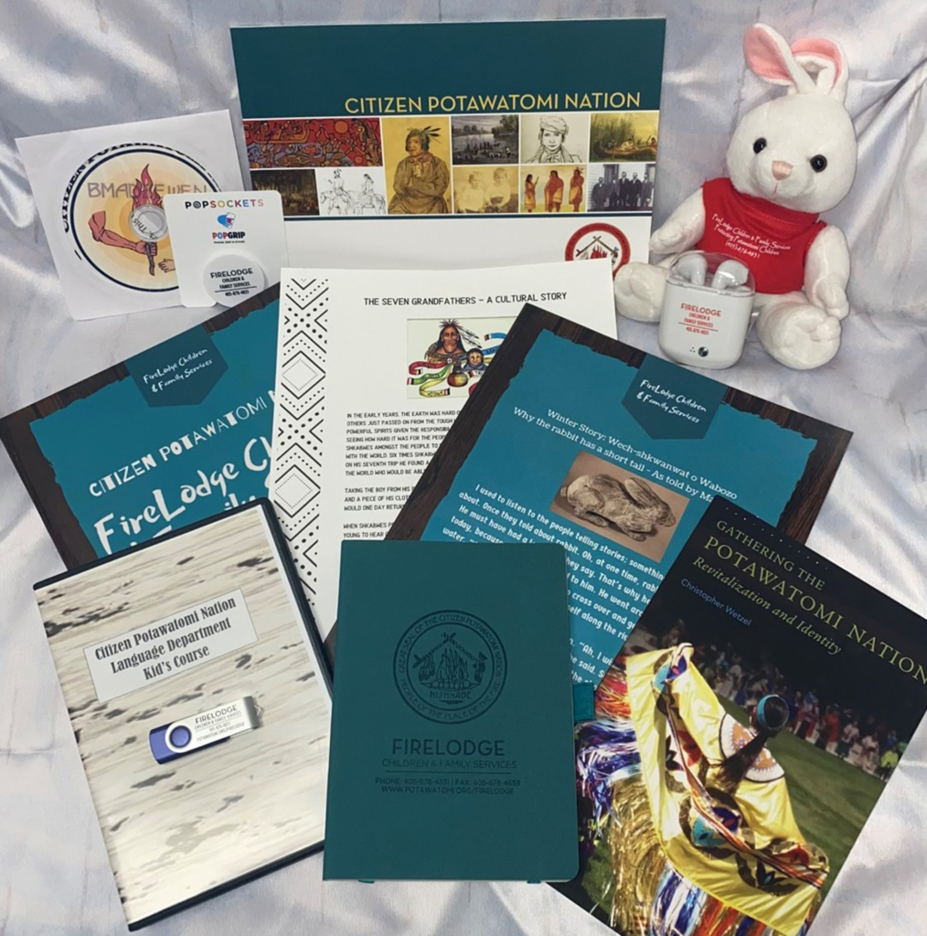 Flat lay of several books, brochures, tech items and a stuffed animal provided by the CPN FireLodge program to CPN foster children. 