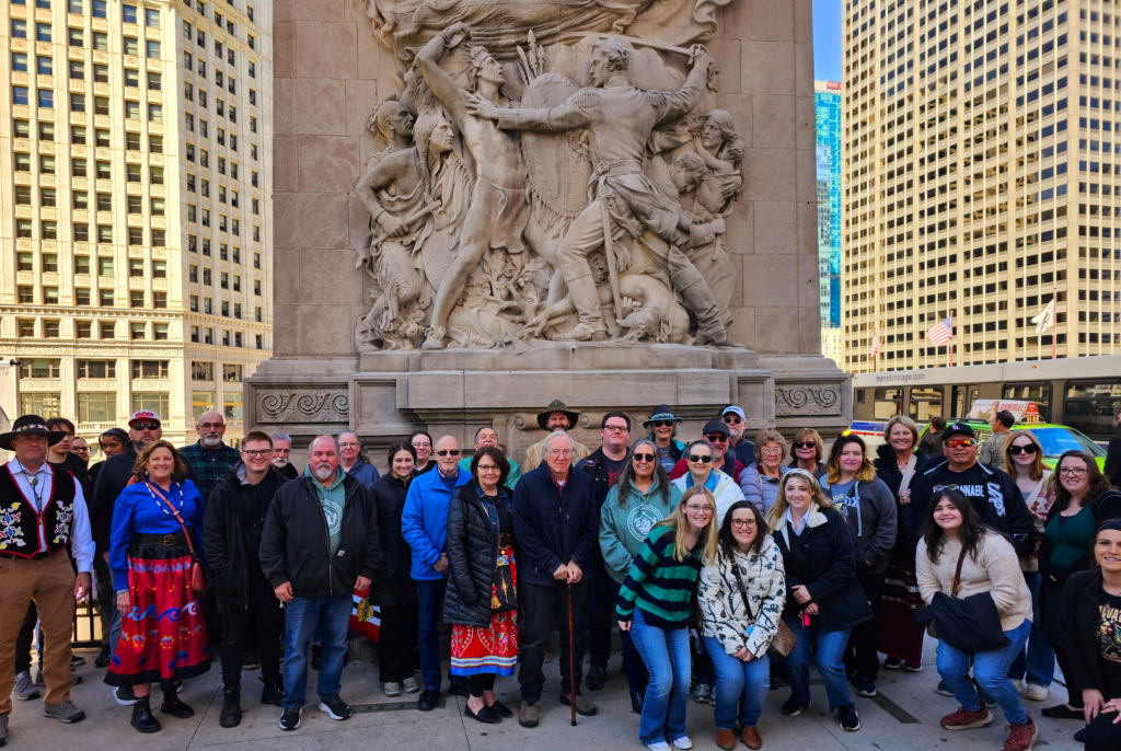 Group photo in front of a carved stone monument. 